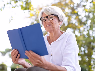 Older woman reading a tablet outside