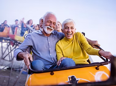 An elderly couple riding a rollercoaster
