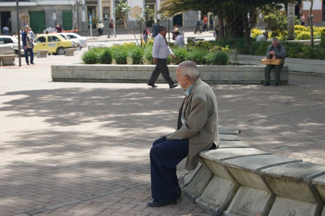 A lonely older man sitting in a park
